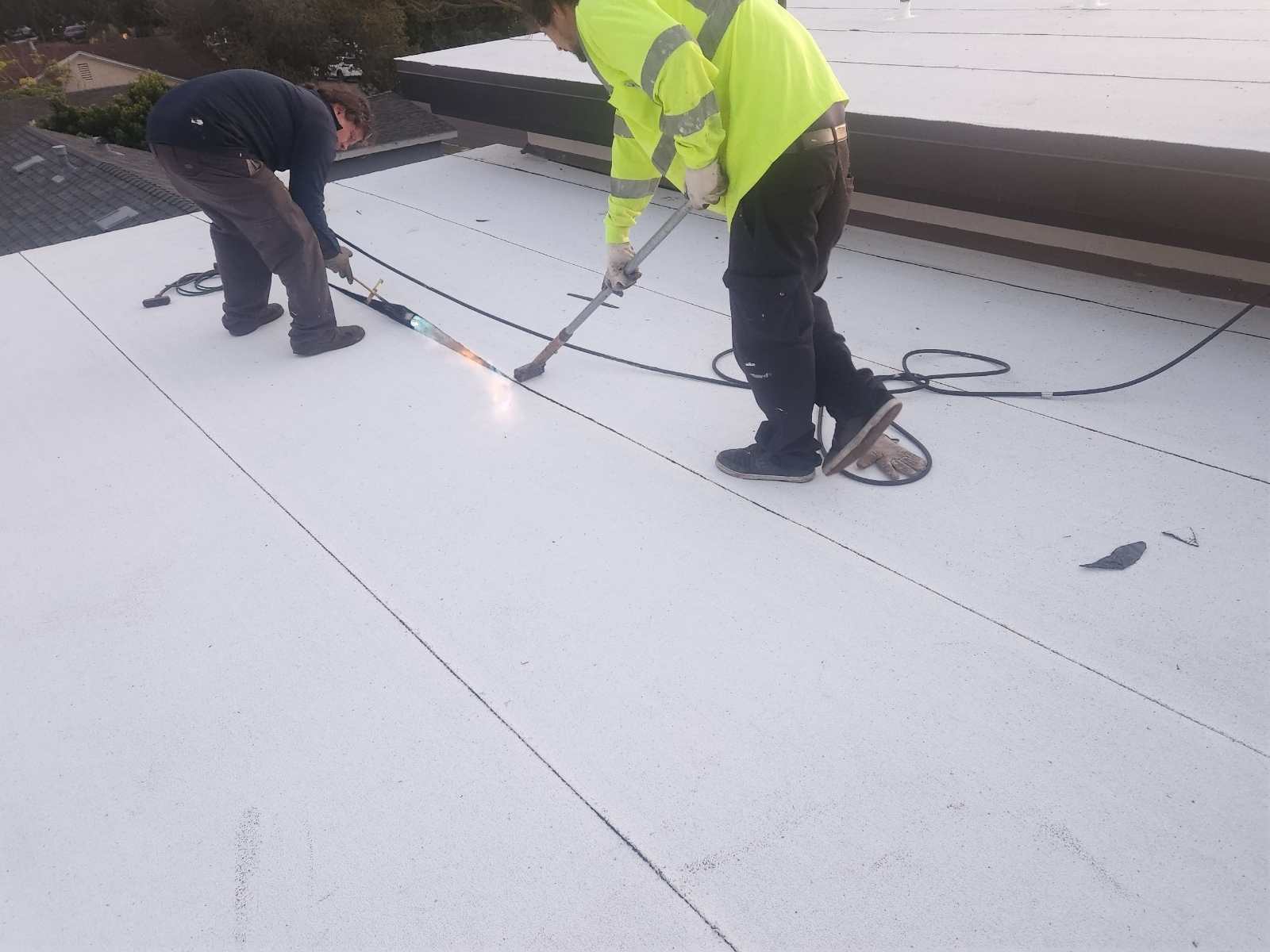 Torch application beside granulated roofing sheets