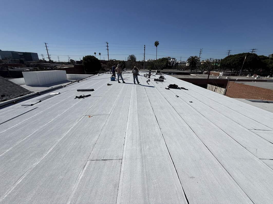 Workers and tools on a broad low-slope roof